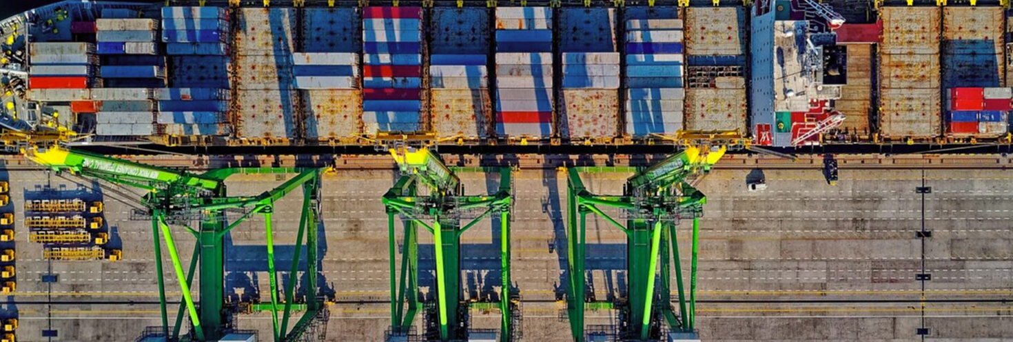 Aerial view of a container ship being loaded by cranes at a port